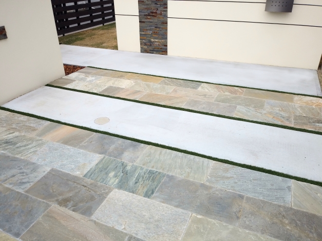 アプローチには長方形の自然石を採用しつつ重い印象にならないよう色味が明るめのもの