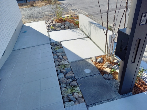 玄関ポーチからの風景。既存のスロープへの道と門柱への導線